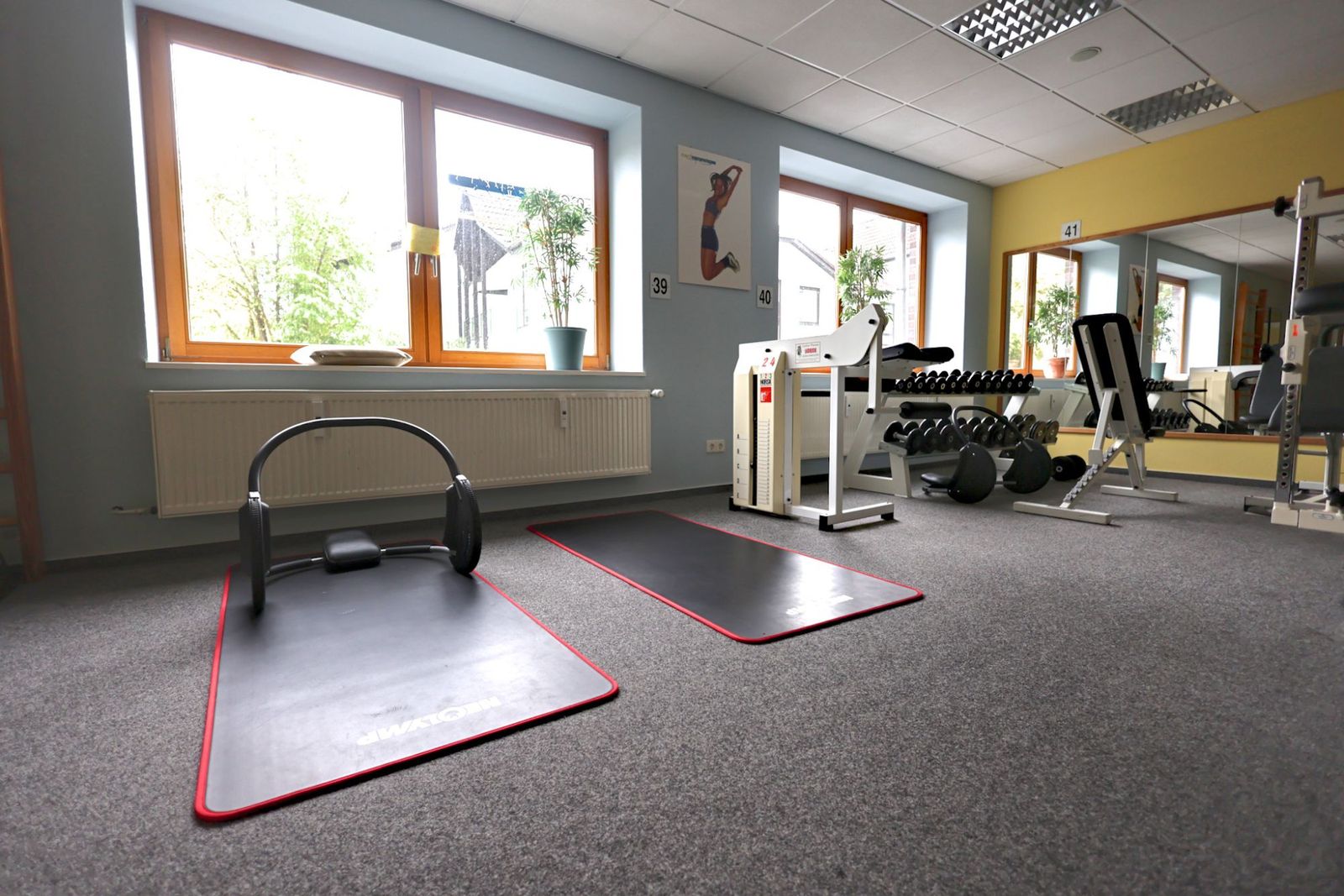 Gymnastikmatten, Kurzhanteln und Fenster im Trainingsbereich