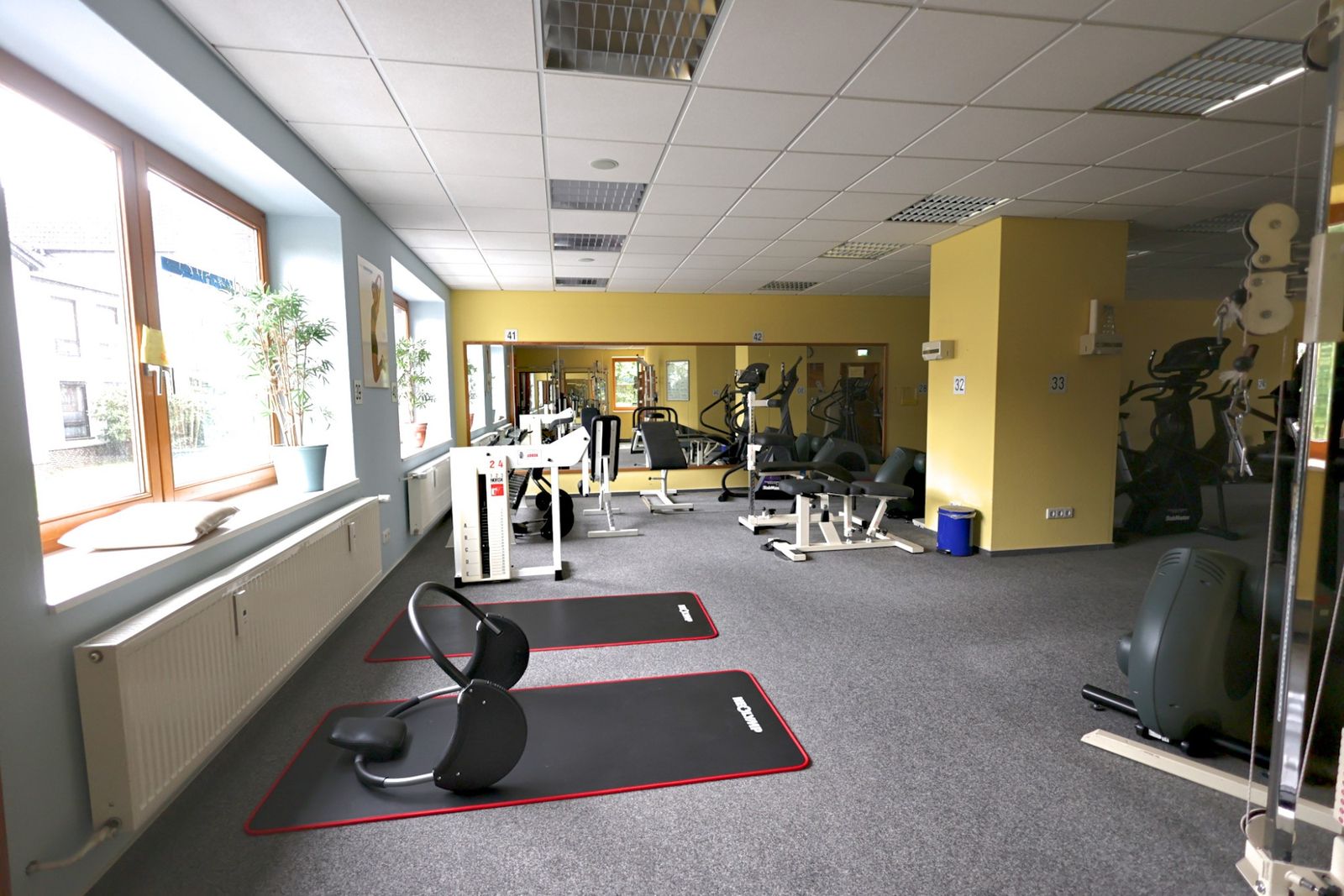 Heller Trainingsbereich mit Matten und Hanteln