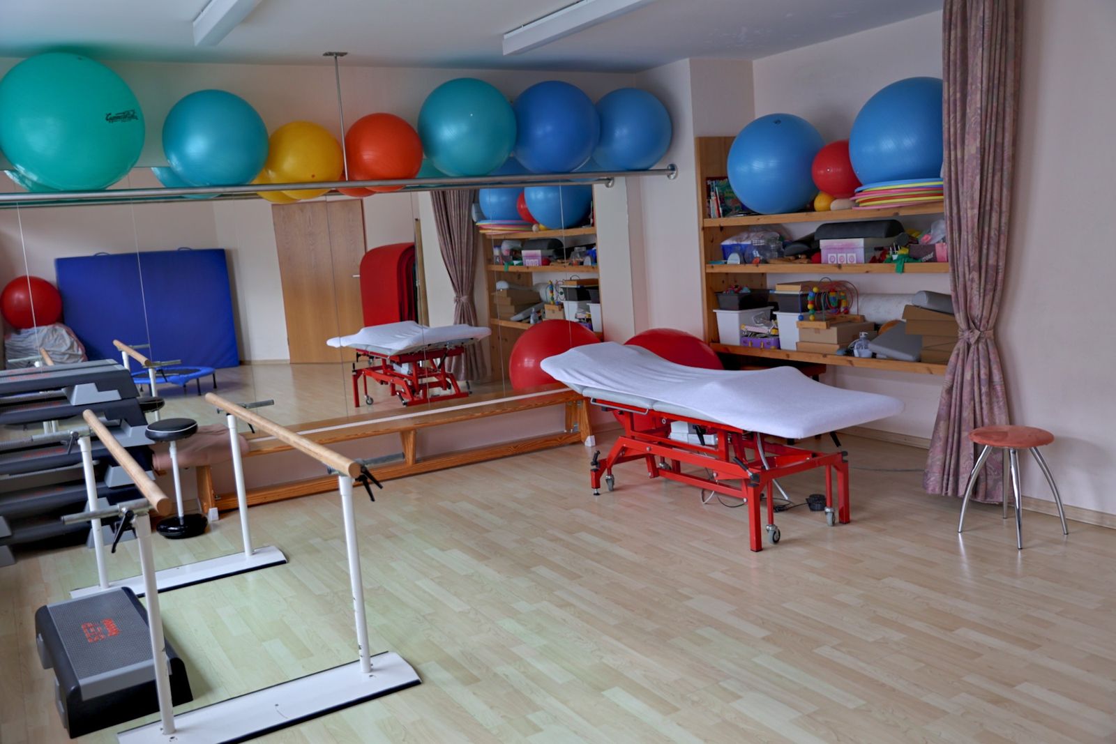 Gymnastikraum mit Gymnastikbällen und Therapieliege
